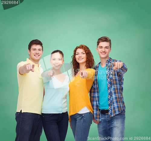 Image of group of smiling teenagers over green board