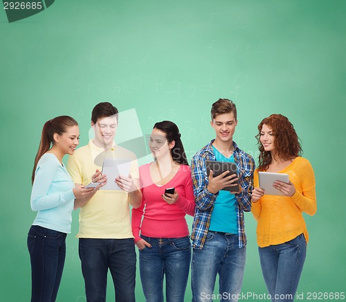Image of group of teenagers with smartphones and tablet pc