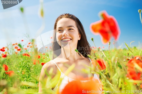 Image of smiling young woman on poppy field