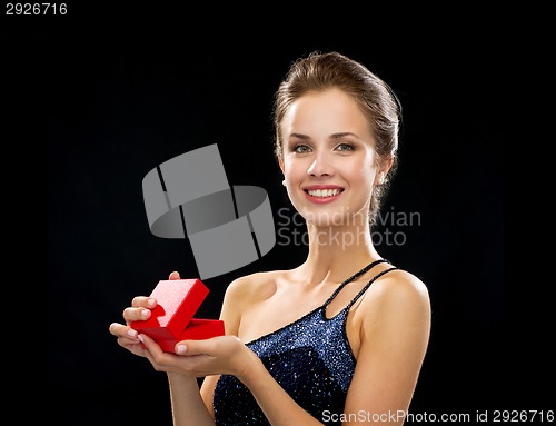 Image of smiling woman holding red gift box