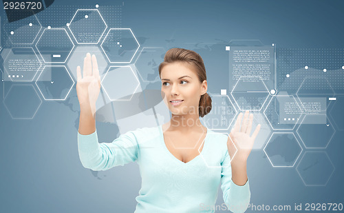 Image of smiling businesswoman working with virtual screen