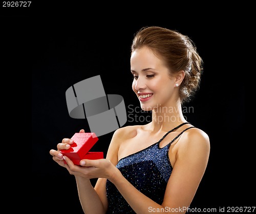 Image of smiling woman holding red gift box