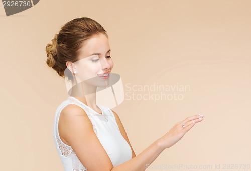 Image of smiling woman in white dress with diamond ring