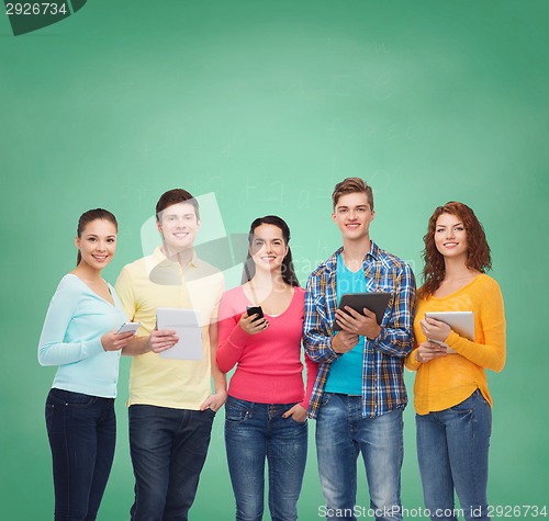 Image of group of teenagers with smartphones and tablet pc