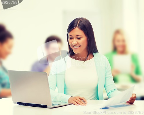 Image of asian businesswoman with laptop and documents