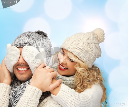 Image of smiling couple in sweaters and santa helper hats