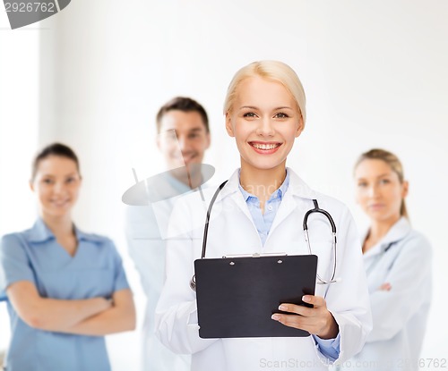 Image of smiling female doctor with clipboard