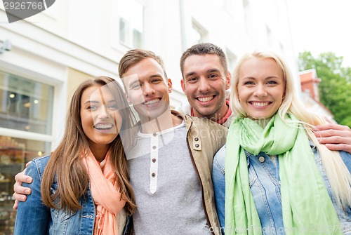 Image of group of smiling friends in city