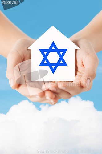 Image of close up of hands holding house with star of david