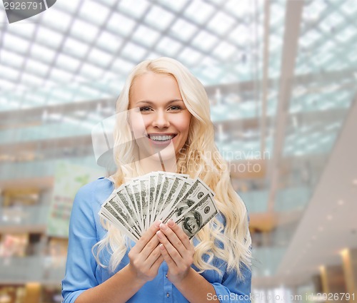 Image of smiling young woman with us dollar money