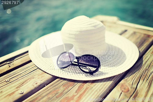 Image of close up of hat and sunglasses at seaside