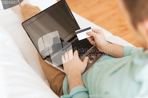 Image of close up of man with laptop and credit card