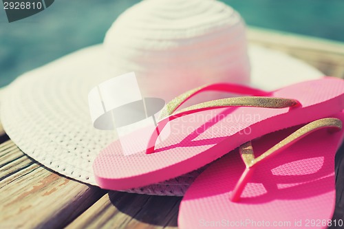 Image of close up of hat and slippers at seaside