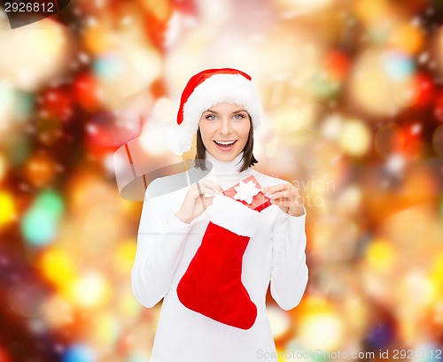 Image of woman in santa hat with gift box and stocking