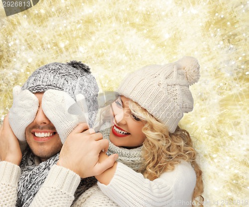 Image of smiling couple in sweaters and santa helper hats