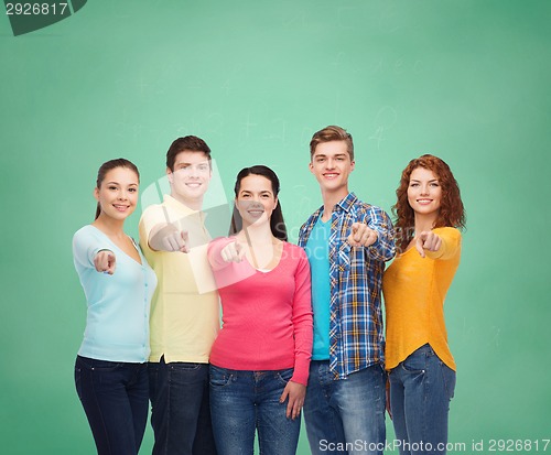 Image of group of smiling teenagers over green board