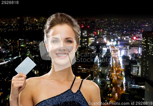 Image of smiling woman in evening dress holding credit card