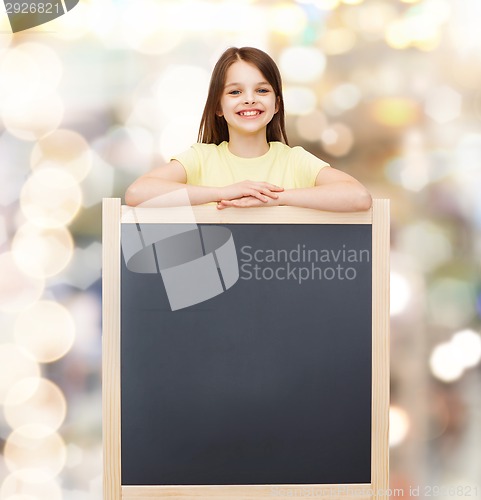 Image of happy little girl with blank blackboard