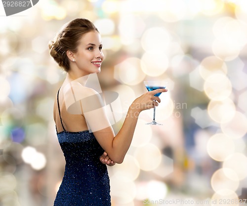 Image of smiling woman holding cocktail