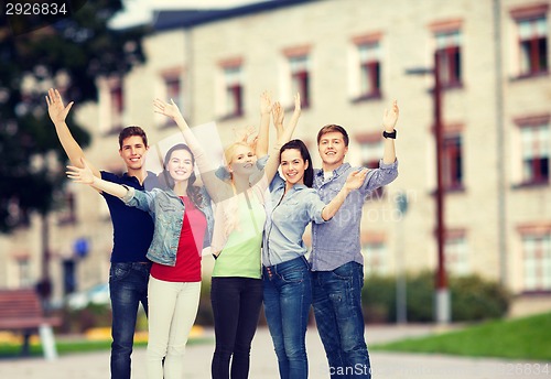 Image of group of smiling students waving hands