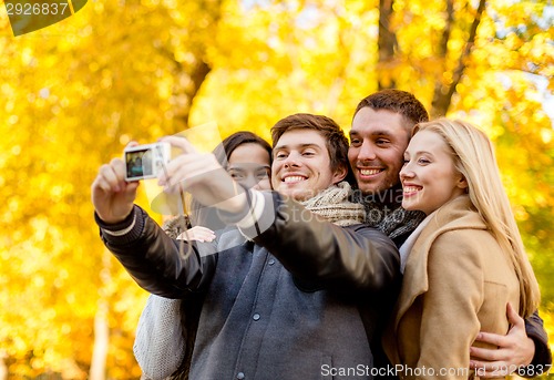 Image of group of smiling men and women making selfie