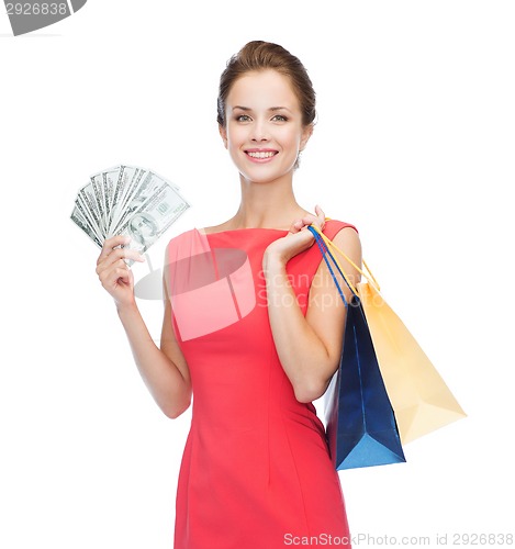 Image of smiling elegant woman in dress with shopping bags