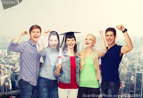 Image of group of standing smiling students with diploma