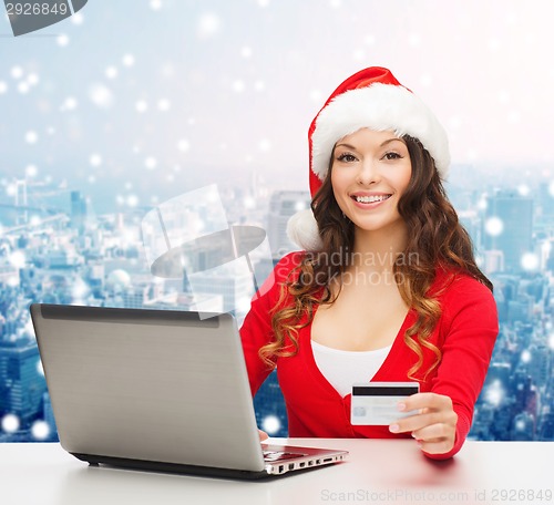 Image of smiling woman with credit card and laptop