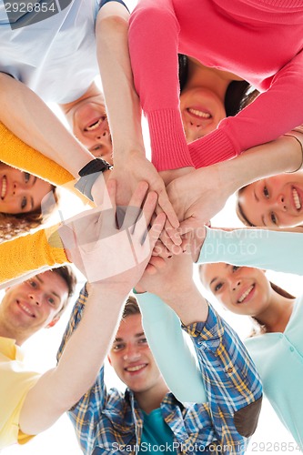 Image of smiling teenagers with hands on top of each other