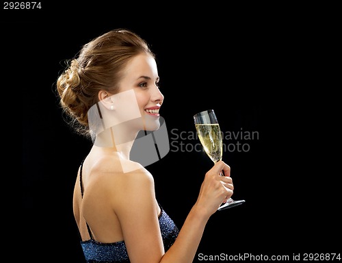 Image of smiling woman holding glass of sparkling wine