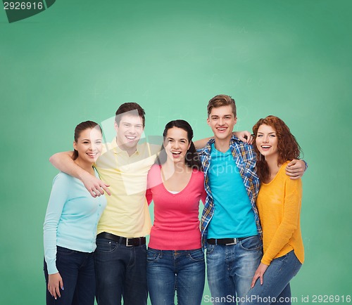 Image of group of smiling teenagers over green board