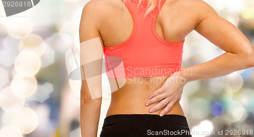 Image of close up of sporty woman touching her back