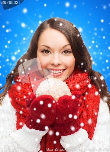 Image of smiling woman in winter clothes with snowball