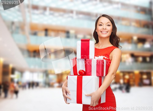 Image of smiling woman in red dress with gift box