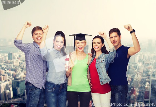 Image of group of standing smiling students with diploma