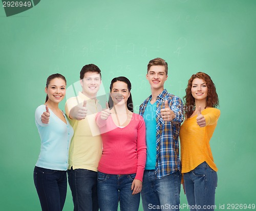 Image of group of smiling teenagers over green board