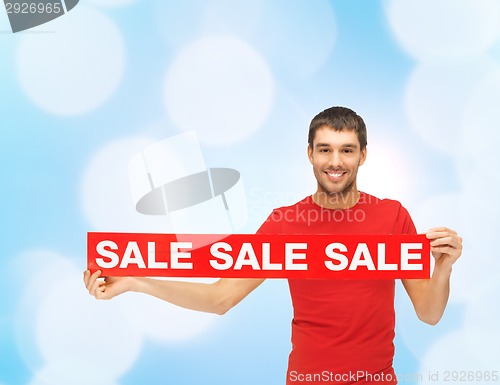 Image of woman in red dress with sale sign