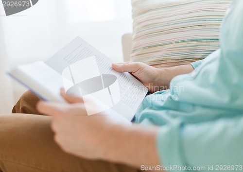 Image of close up of man reading book at home