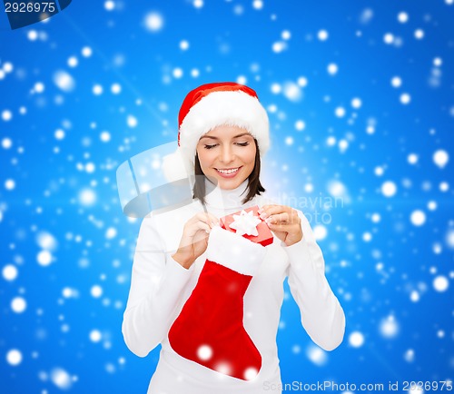 Image of woman in santa hat with gift box and stocking