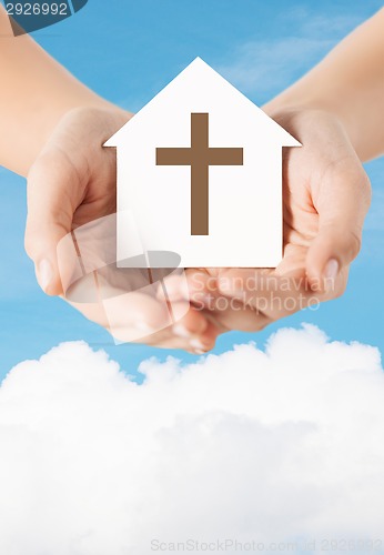 Image of close up of hands and paper house with cross