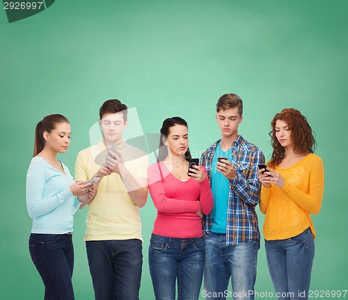 Image of group of serious teenagers with smartphones