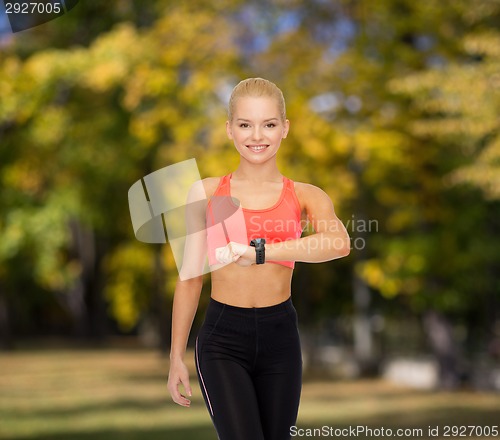 Image of smiling woman with heart rate monitor on hand