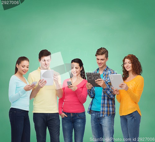 Image of group of teenagers with smartphones and tablet pc