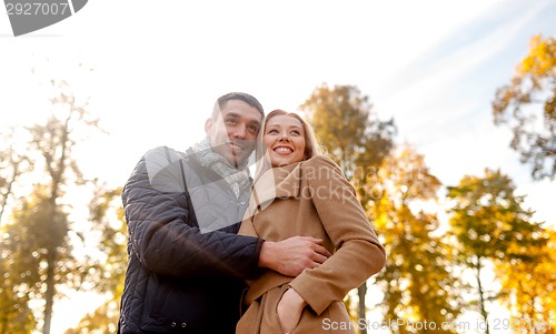 Image of smiling couple hugging in autumn park