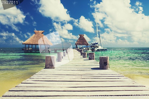 Image of wooden pier with blue water around