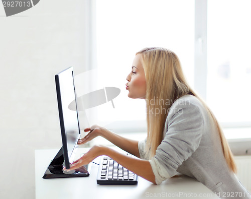 Image of woman sending kisses with computer monitor
