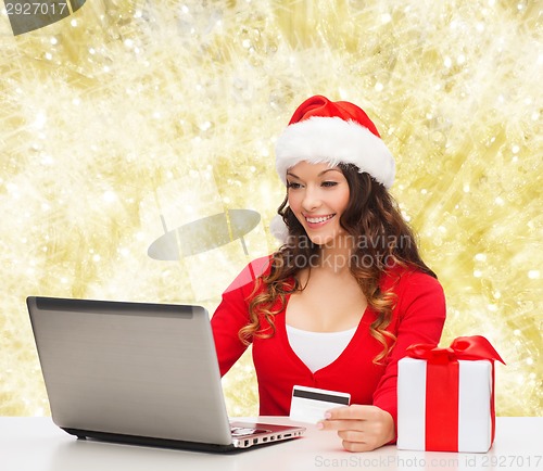 Image of smiling woman with credit card and laptop