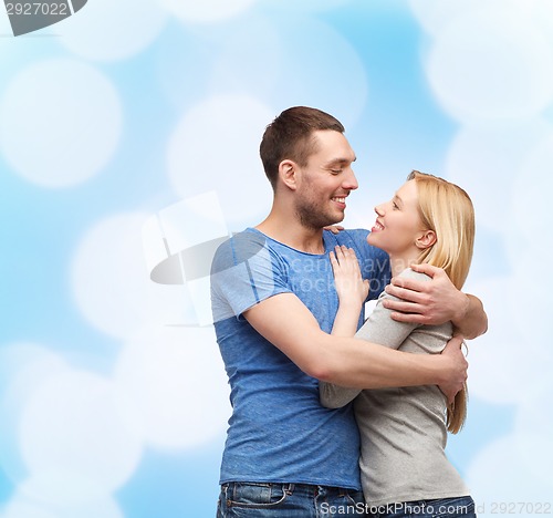 Image of smiling couple hugging and looking at each other