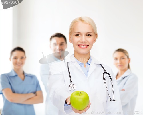 Image of smiling female doctor with green apple