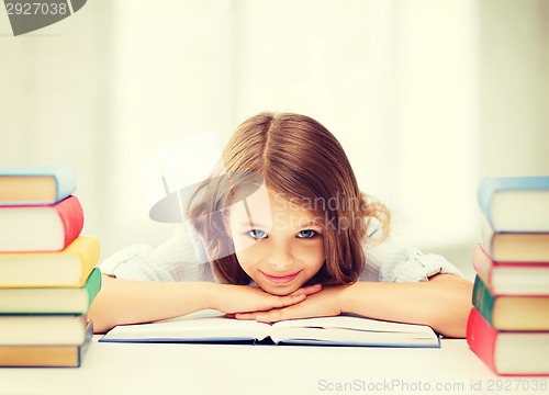 Image of pretty girl with many books at school